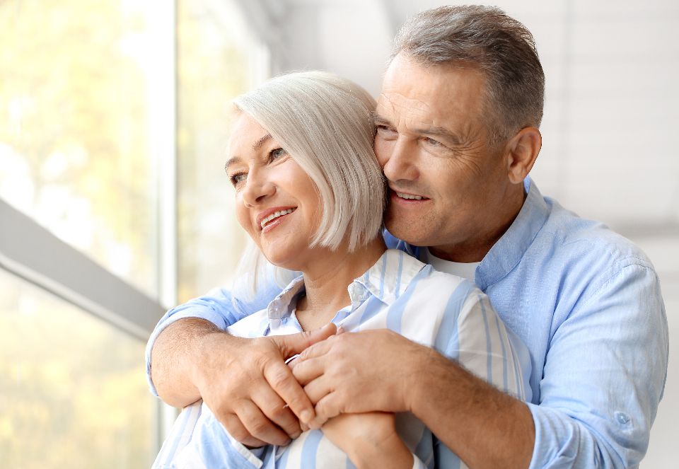 Senior couple embracing by a bright window